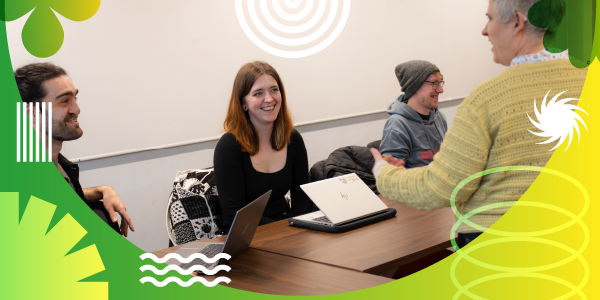 Two students interacting with an academic in a seminar.